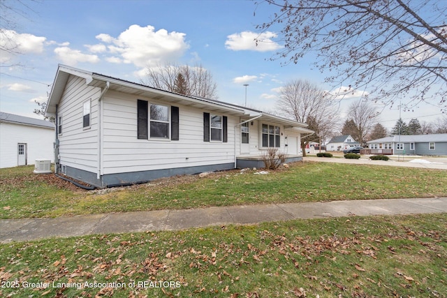 bungalow with a garage, a front yard, concrete driveway, and central AC unit