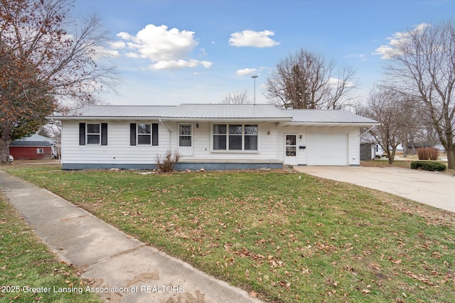 single story home featuring metal roof, an attached garage, driveway, and a front yard