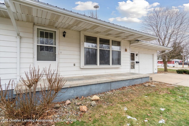 property entrance featuring concrete driveway and an attached garage