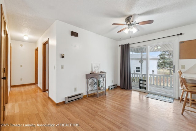 sitting room with a textured ceiling, a baseboard radiator, baseboards, baseboard heating, and light wood-type flooring