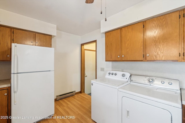 washroom with a baseboard heating unit, a ceiling fan, light wood-type flooring, independent washer and dryer, and cabinet space