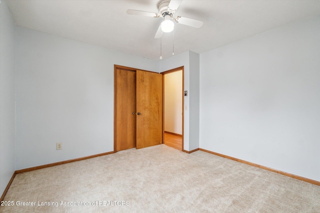 unfurnished bedroom with carpet, a closet, ceiling fan, and baseboards