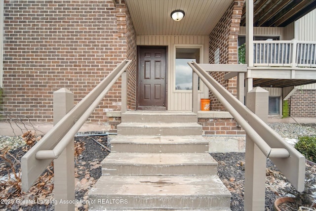 entrance to property featuring brick siding