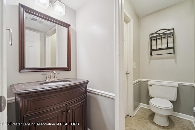 bathroom with baseboards, visible vents, vanity, and toilet