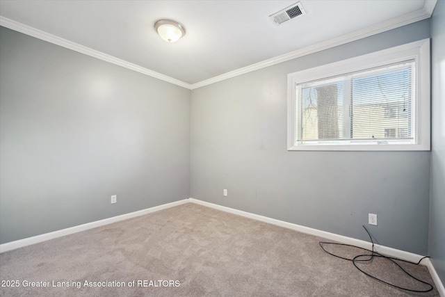 spare room featuring carpet, visible vents, crown molding, and baseboards