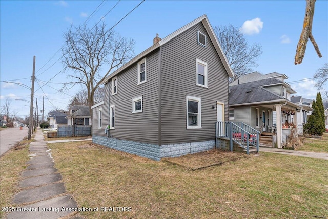 view of front of home with a chimney, a porch, and a front yard