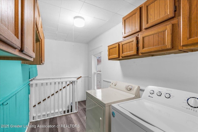 laundry room with dark wood-type flooring, washer and clothes dryer, and cabinet space