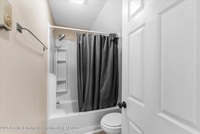 bathroom featuring shower / bath combination with curtain and toilet