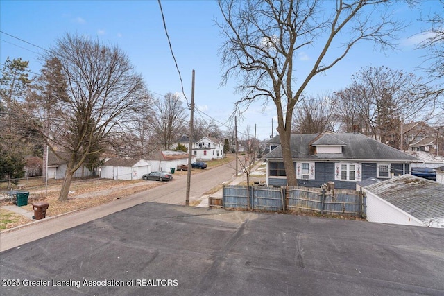 view of front of home with a fenced front yard, a residential view, and a gate