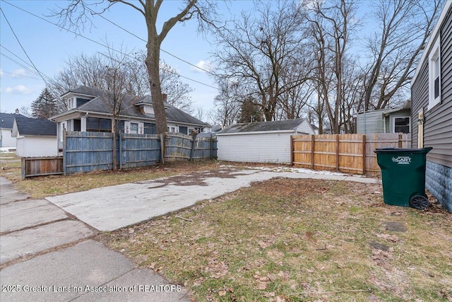 view of yard with a storage unit, an outdoor structure, and a fenced backyard