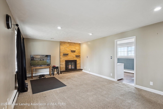 exercise room with a baseboard heating unit, a fireplace, carpet flooring, and baseboards