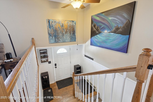 entrance foyer featuring a ceiling fan, stairway, and wood finished floors