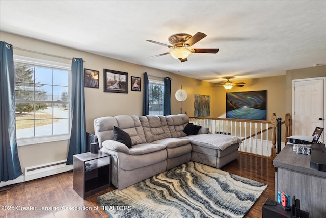 living area featuring a baseboard heating unit, plenty of natural light, and wood finished floors