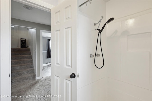 bathroom featuring a shower and baseboards