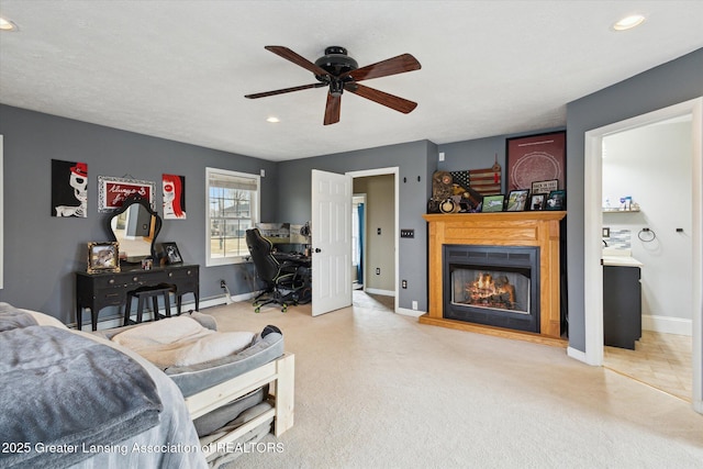 bedroom with a lit fireplace, baseboards, and carpet flooring