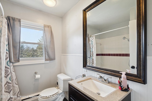 full bath featuring curtained shower, toilet, a wainscoted wall, vanity, and baseboard heating