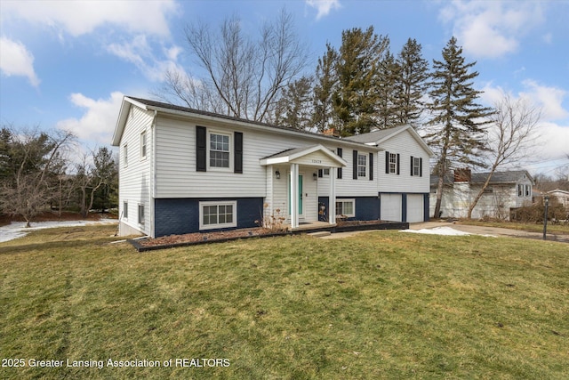 raised ranch with an attached garage, driveway, and a front yard