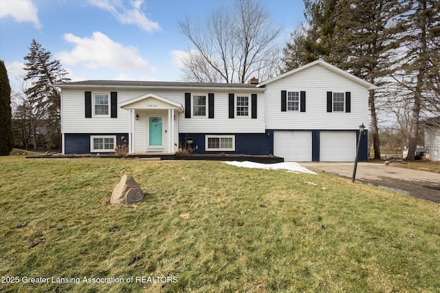 bi-level home featuring a garage, concrete driveway, and a front yard