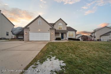 traditional-style home with a garage, a front lawn, and concrete driveway