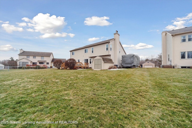 back of property featuring an outbuilding, a yard, and a shed