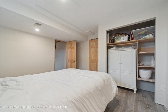 bedroom featuring wood finished floors and visible vents