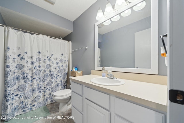 bathroom featuring curtained shower, vanity, and toilet