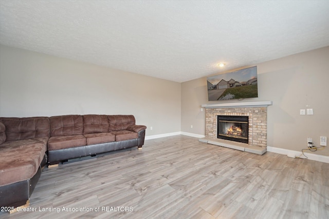 unfurnished living room featuring a textured ceiling, baseboards, and wood finished floors