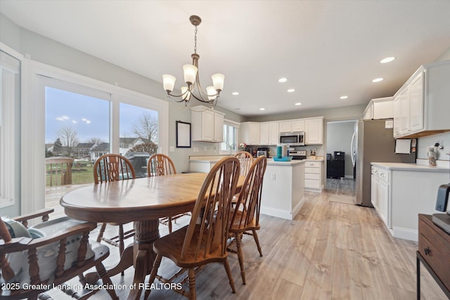 dining space with an inviting chandelier, light wood-style flooring, and recessed lighting