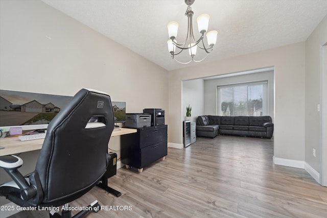 office with light wood-style floors, a textured ceiling, baseboards, and an inviting chandelier