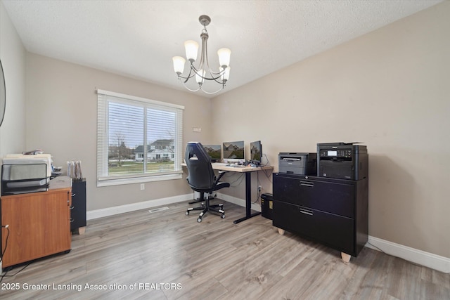 home office with baseboards, a textured ceiling, light wood finished floors, and an inviting chandelier