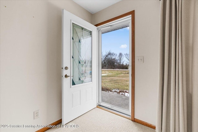 doorway with carpet flooring and baseboards