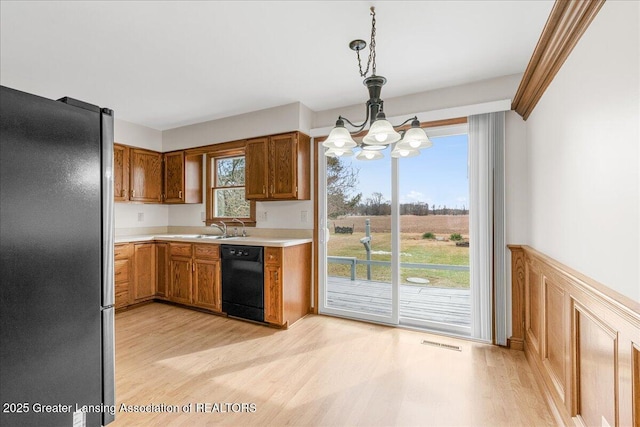 kitchen with dishwasher, light wood finished floors, visible vents, and freestanding refrigerator