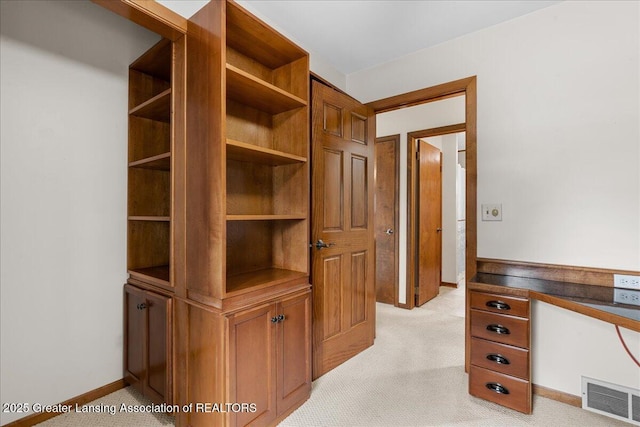 hall with visible vents, light carpet, and baseboards