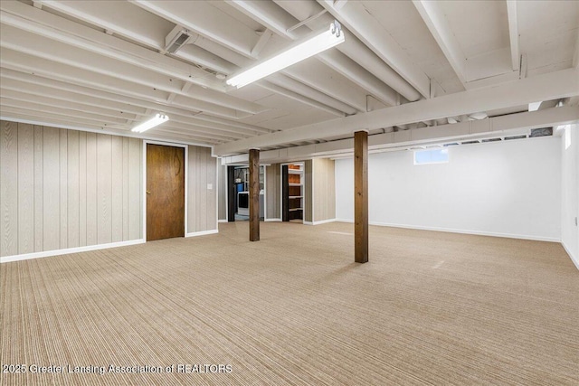 finished basement with carpet, wooden walls, and baseboards