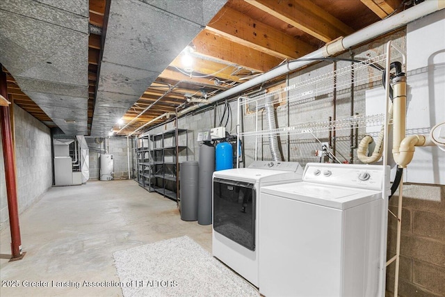 laundry area featuring heating unit, laundry area, separate washer and dryer, and gas water heater