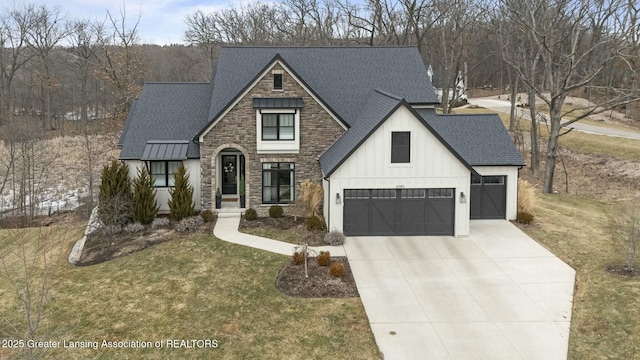 view of front of home with board and batten siding, a shingled roof, concrete driveway, a front yard, and stone siding