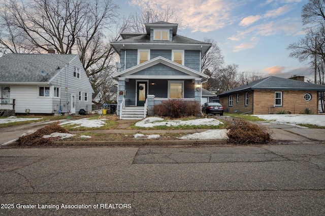 american foursquare style home with driveway and covered porch