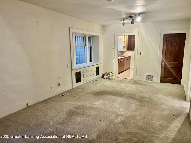 unfurnished living room featuring visible vents and light colored carpet