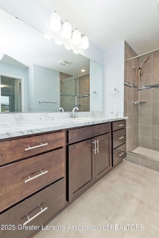 bathroom featuring a shower stall and vanity