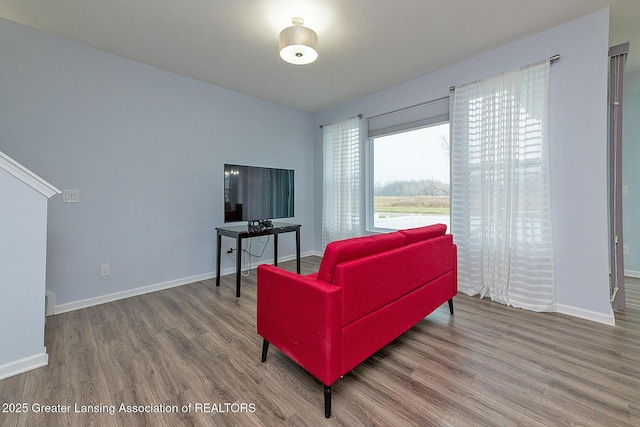 sitting room with baseboards and wood finished floors