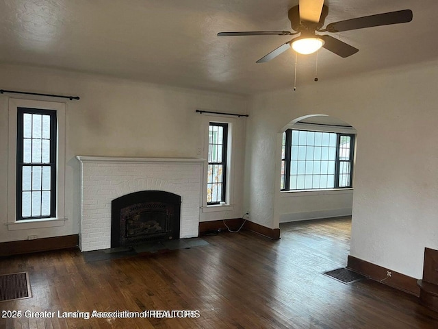 unfurnished living room featuring a wealth of natural light, wood finished floors, and visible vents