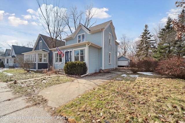 view of front facade featuring a sunroom and a detached garage