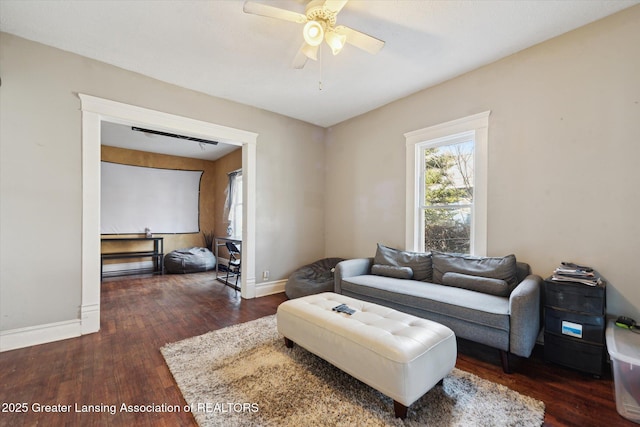 living room featuring wood finished floors, a ceiling fan, and baseboards