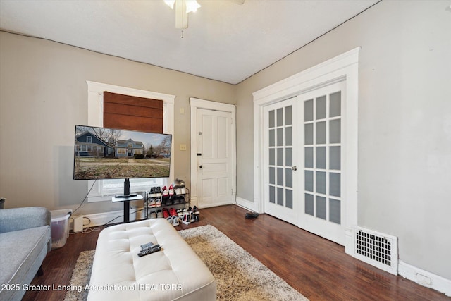 interior space with french doors, visible vents, a ceiling fan, wood finished floors, and baseboards