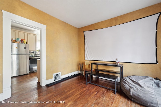 interior space featuring baseboards, visible vents, and hardwood / wood-style floors