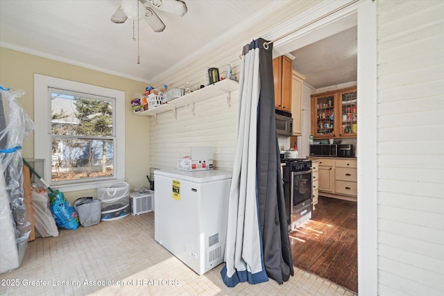 interior space with laundry area, light wood-style flooring, ornamental molding, and a ceiling fan