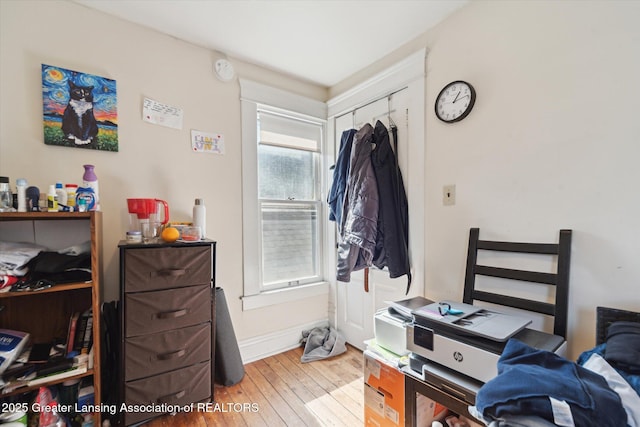 bedroom with a closet, light wood-style flooring, and baseboards