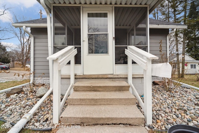 entrance to property featuring a shingled roof