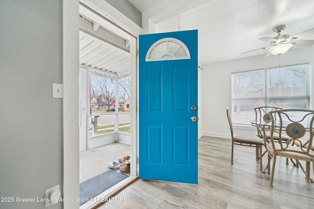 entryway featuring wood finished floors, a ceiling fan, and baseboards