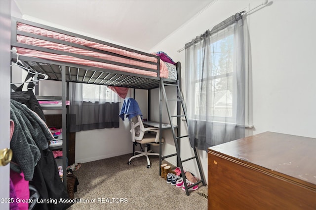 carpeted bedroom featuring multiple windows and baseboards